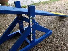 a blue wooden bench sitting on top of dry grass