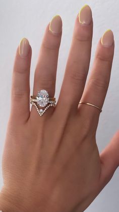 a woman's hand with two gold rings and a diamond ring on her finger