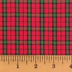 a red and green plaid fabric next to a ruler