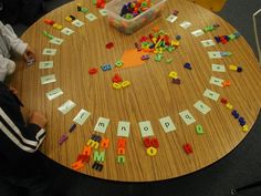 a young boy sitting at a table playing with letters and magnets on the board