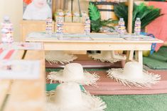 two hats are sitting on the floor in front of a table with drinks and candy