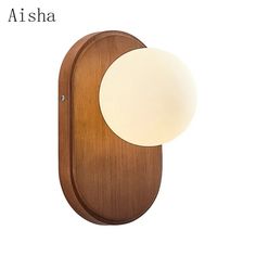 a wooden wall light with a white ball on the front and back side, against a white background