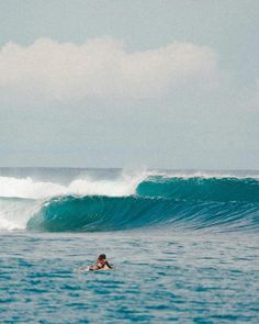 a man riding a wave on top of a surfboard in the middle of the ocean