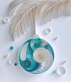 a glass ornament sitting on top of a table next to a white feather