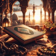 an open book sitting on top of a table next to a vase with flowers in it