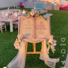 an open book is sitting on top of a wooden easer with flowers and ribbons