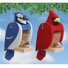 two birds sitting on top of bird feeders