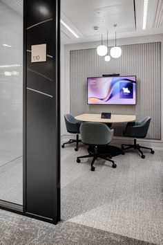 an office meeting room with a flat screen tv on the wall