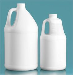 two white plastic jugs sitting side by side on a blue background with one empty