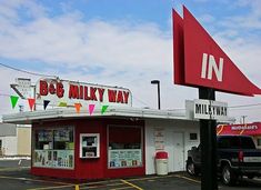 a red and white building with a sign in front of it that says bob's milky way