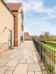 a brick building with a black iron fence and green grass in the backround