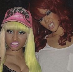 two women wearing wigs and hats posing for the camera