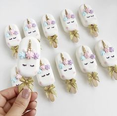 a hand is holding some fake unicorn nails