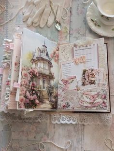 an open book sitting on top of a table next to a cup and saucer