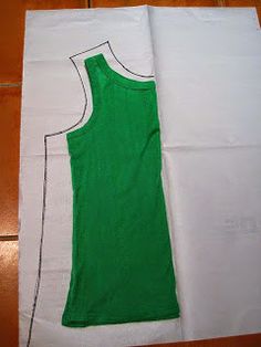 a green tank top sitting on top of a white piece of paper