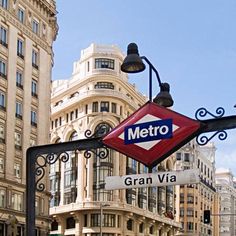 a metro sign hanging off the side of a metal pole