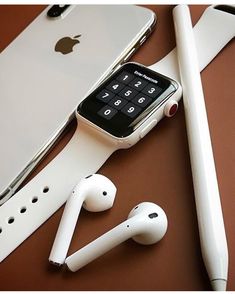 an apple watch and ear buds are sitting on a table next to some other items