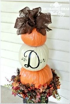 three pumpkins stacked on top of each other with the letter d painted on them