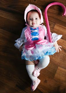 a baby dressed in pink and blue with an umbrella