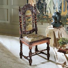 an old chair with a hat on it in front of some paintings and other items