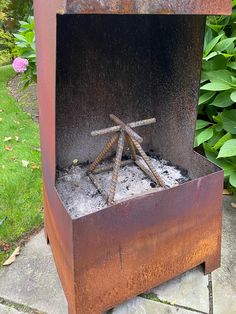 an outdoor fire pit with sticks sticking out of it