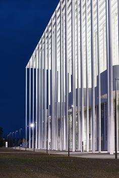 the building is white and has columns on each side that are lit up at night