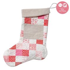 a christmas stocking with red and white patchwork on the bottom, hanging from a string