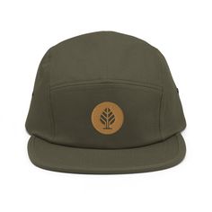 a green hat with a tree on the front and brown leather patch at the peak