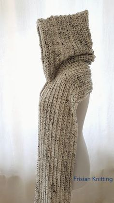 a white mannequin wearing a knitted scarf