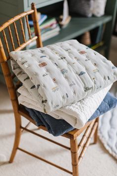 a stack of blankets sitting on top of a wooden chair