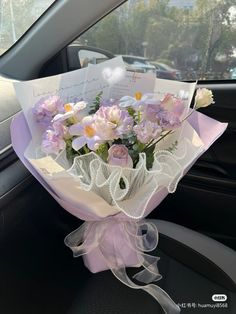 a bouquet of flowers sitting in the back seat of a car with a note attached to it