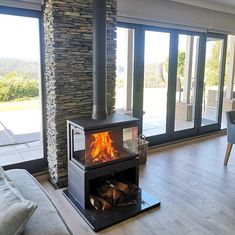 a living room filled with furniture and a fire place next to a glass door window