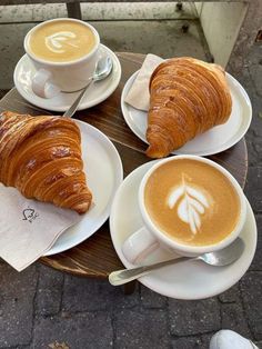 coffee and croissants are sitting on the table next to eachother