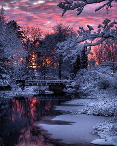 the sun is setting over a river with snow on it