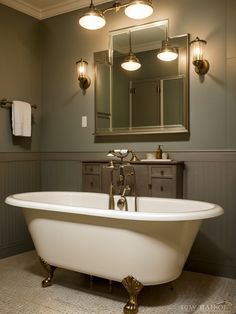 a bath tub sitting under a bathroom mirror