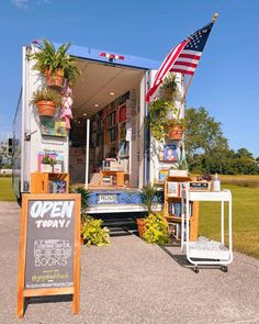 an open book store on the side of a road with a flag flying in the background