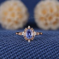 an oval shaped tan and white diamond ring on top of a blue blanket with two balls in the background