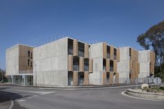 the building is made out of concrete and has multiple balconies on each side