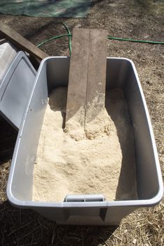 a sandbox with a shovel in it on the ground