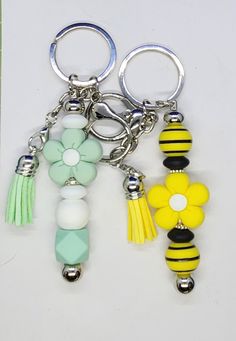 two key chains with flowers and beads attached to them