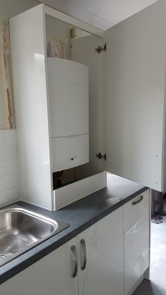 an empty kitchen with white cabinets and black counter tops is seen in this image from the doorway