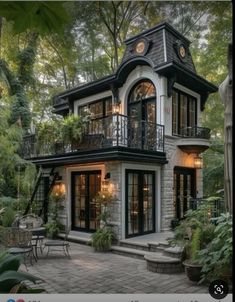 an image of a small house in the middle of some trees and bushes with lots of windows