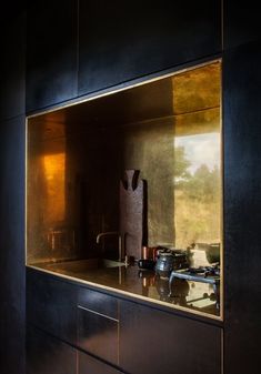 a kitchen with black cabinets and metallic counter tops