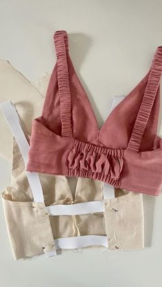 two pieces of clothing sitting on top of each other next to an object that looks like a bra