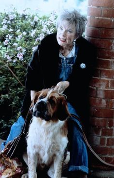 an old woman sitting next to her dog