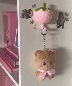 a teddy bear keychain hanging from a wall