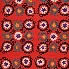 an orange and blue flowered design on a red background with black, white, and yellow flowers