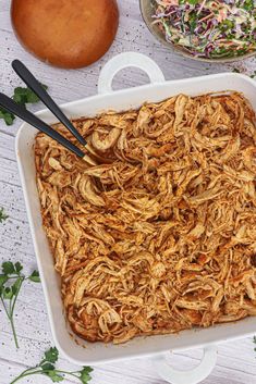 a casserole dish filled with shredded meat and vegetables