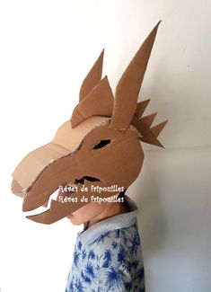 a cardboard dragon mask is shown on top of a paper box with the words, how do you make it?