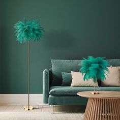 a living room with a couch, table and two tall green feathers on the floor